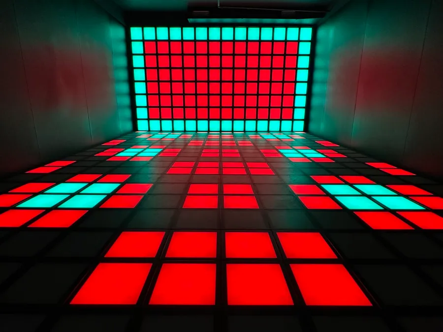 Squarena arena with a floor and wall of glowing red and teal tiles
